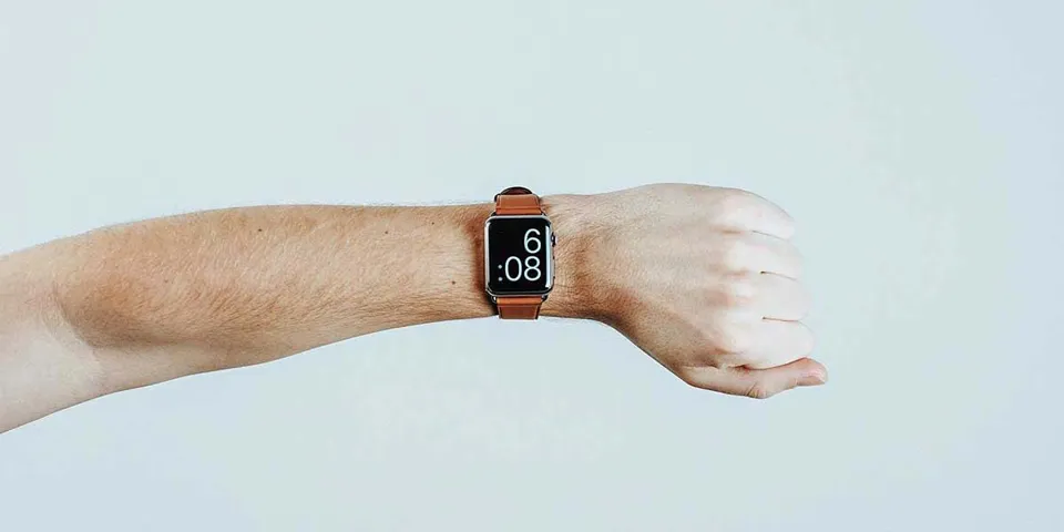 What motivates people to write customer reviews shown through a person checking the time on a smartwatch