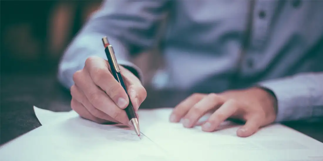 Customer testimonials – person writing feedback and signing a review document