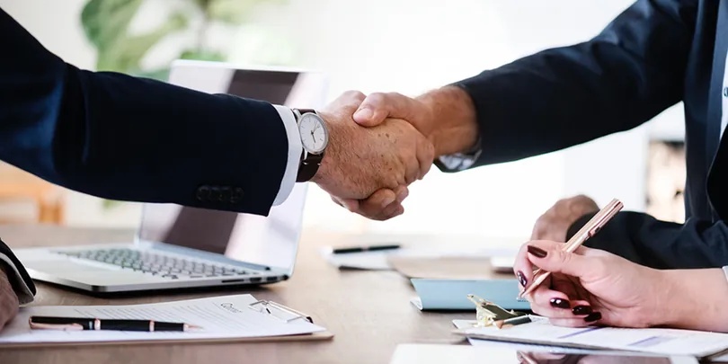 B2B testimonials concept showing business handshake during a professional agreement