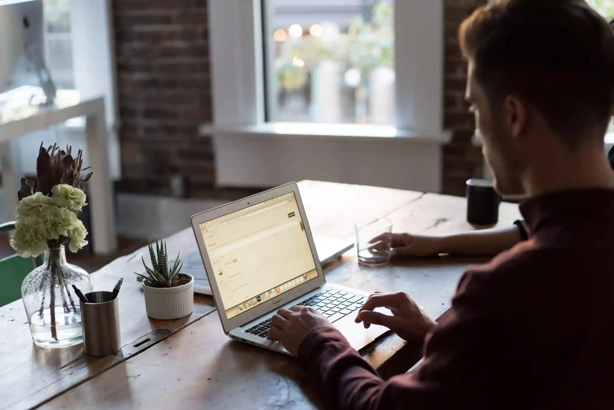 Person working on a laptop in a modern workspace, representing Amazon Seller Apps for managing and growing an Amazon business