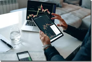 Person reviewing app performance charts on tablet and laptop