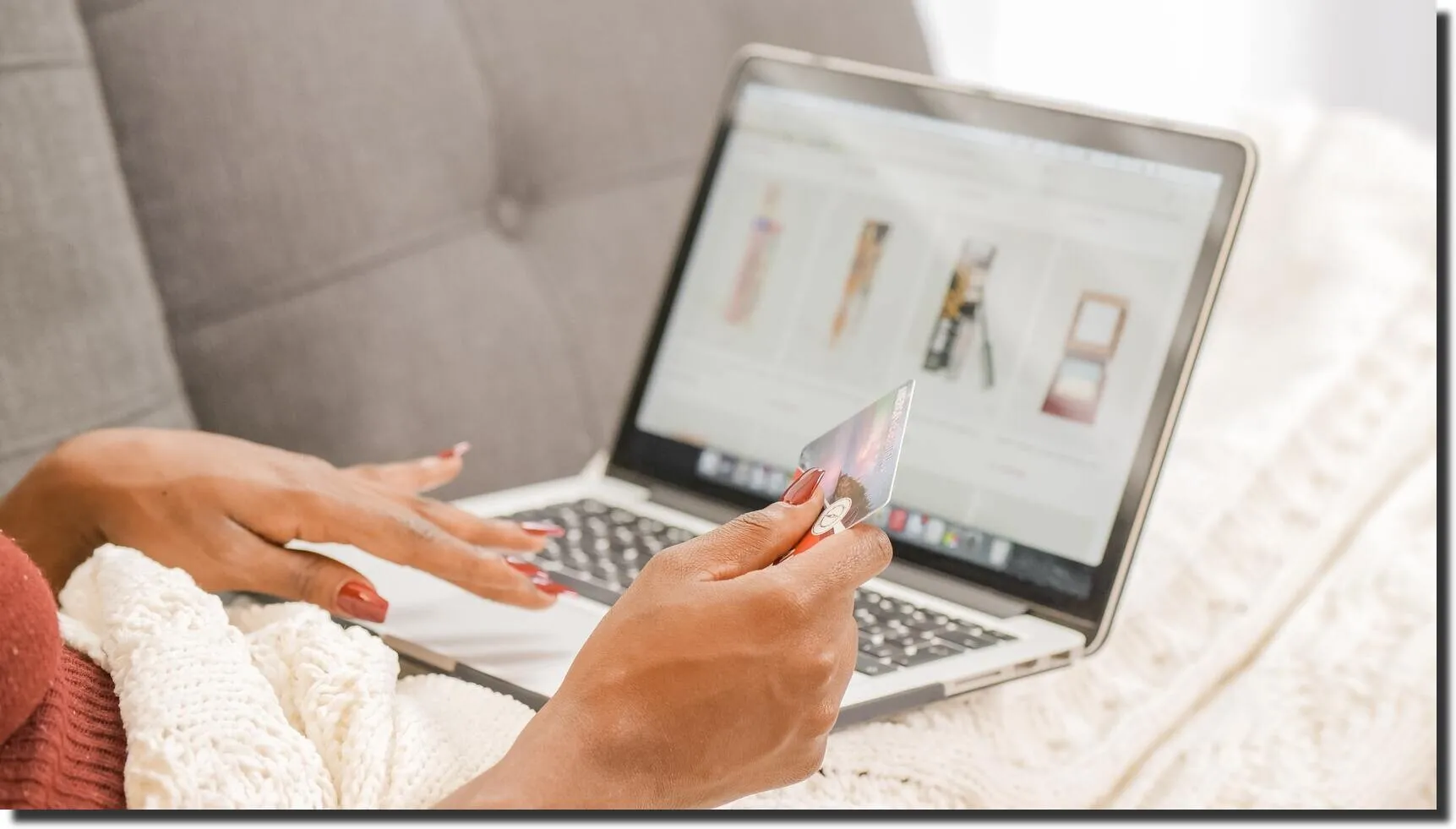 Woman holding a gift card while shopping on a Shopify store using her laptop